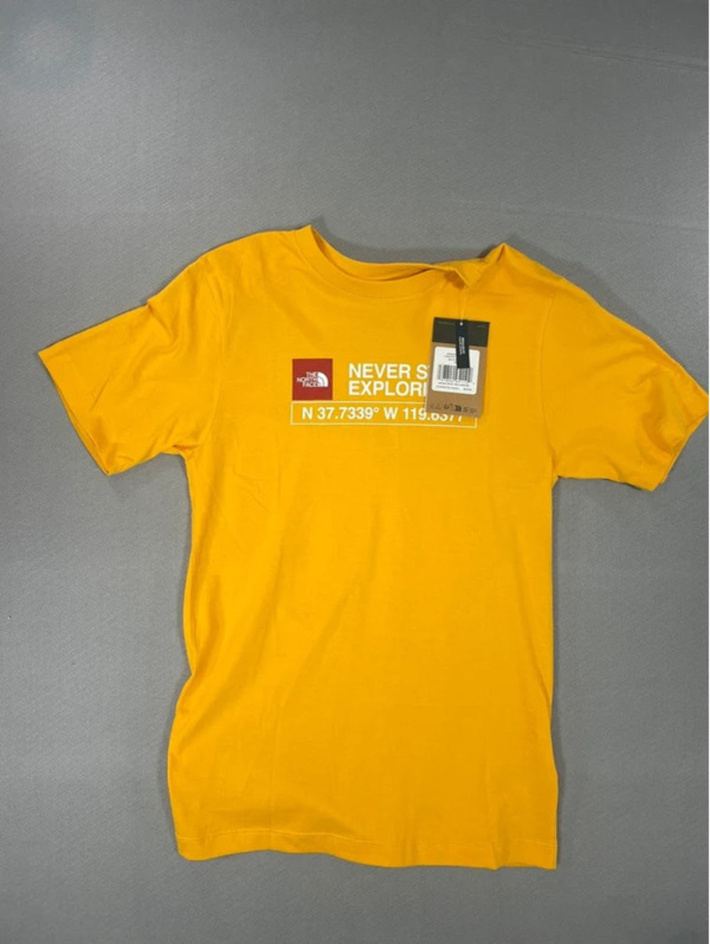 The Northface yellow “Never stop exploring” T-shirt Size XS